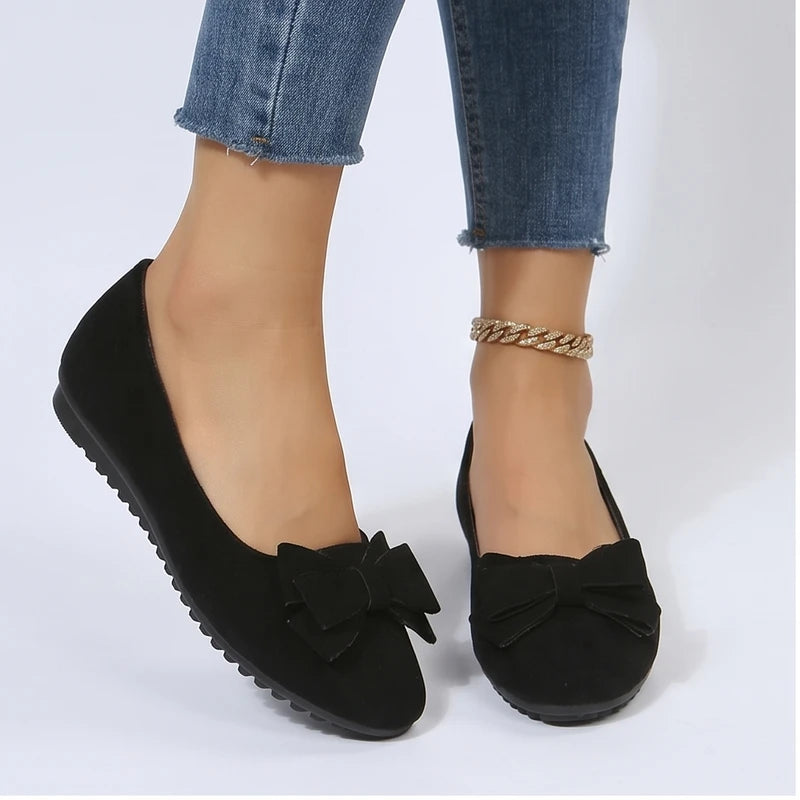 Model wearing Black Briony Suede Bow Flats in studio