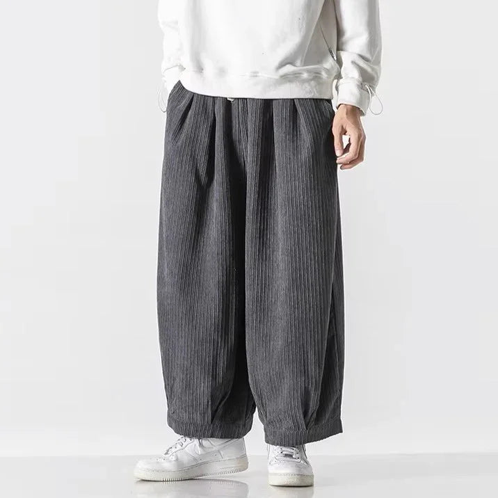 Men's oversized corduroy pants featuring deep pleats and an elastic waistband for comfortable, effortless style.