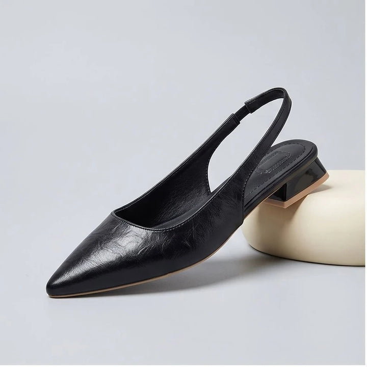 Black leather flats in a studio background