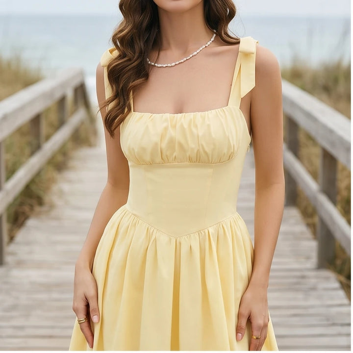 Model wearing L Solara Tie-Strap Yellow Mini Dress outdoors
