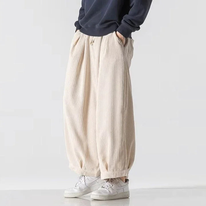 Vera Corduroy Pants featuring deep pleats, wide-leg silhouette, and an elastic waistband for comfort.
