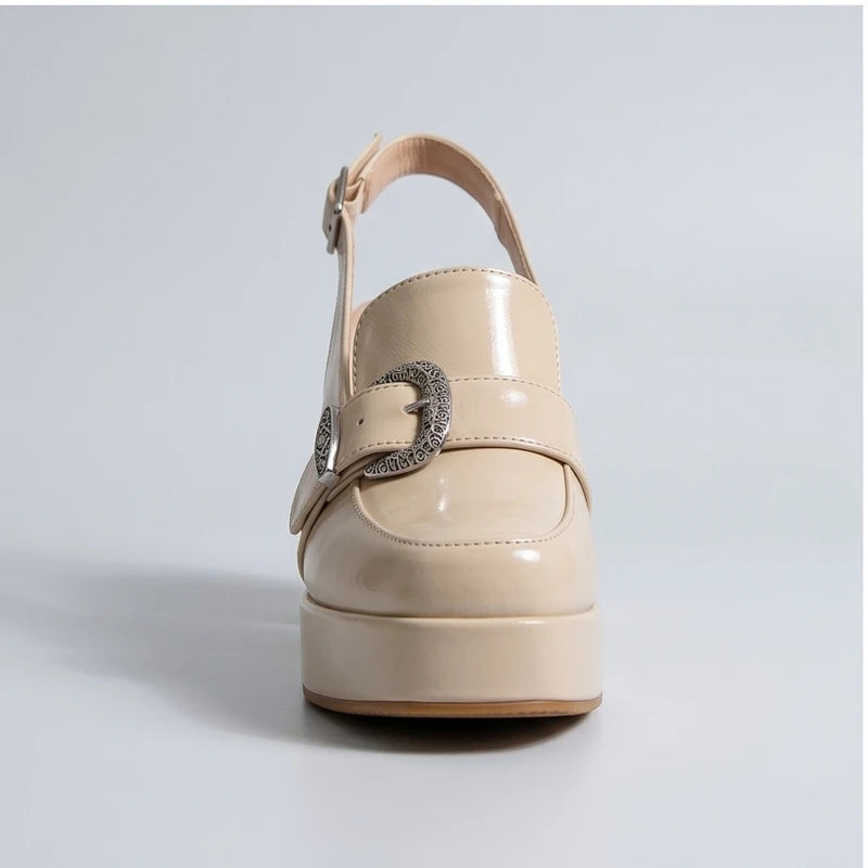 Beige patent leather Belinda platform slingback heels with ornate buckle.