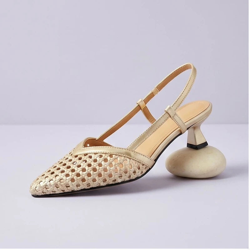 Gold woven sandals in a studio background