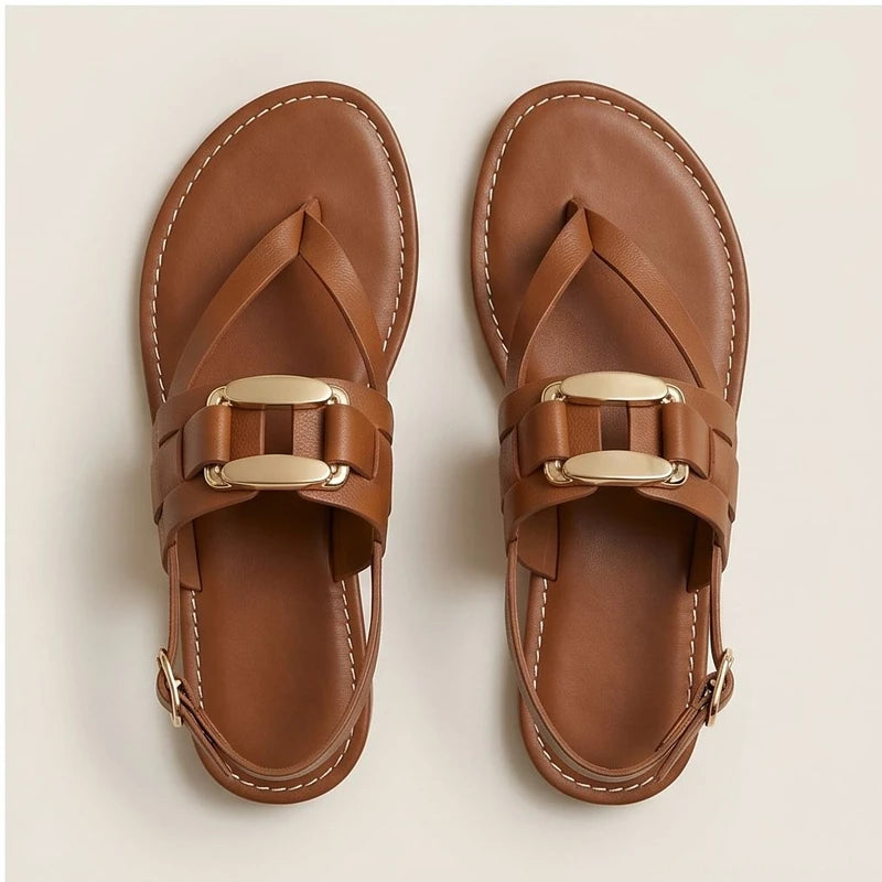 Brown leather t-strap sandals with gold buckle detail and slingback strap.