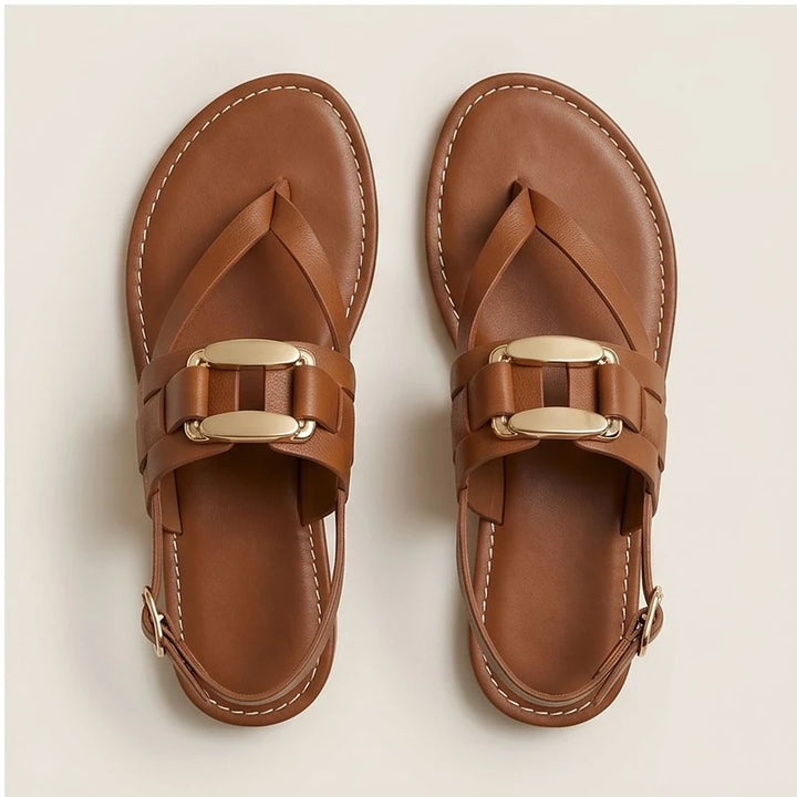 Brown leather t-strap sandals with gold buckle detail and slingback strap.