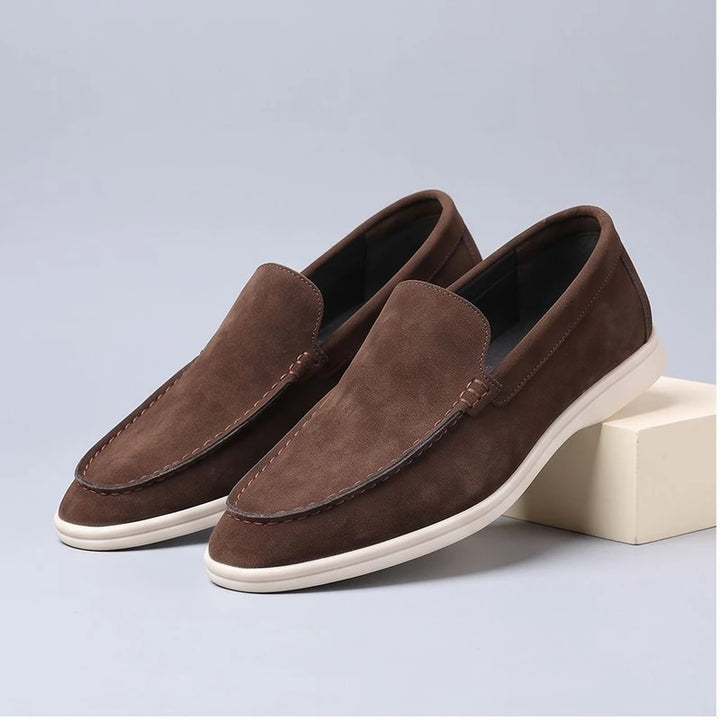 brown suede loafers in a studio background