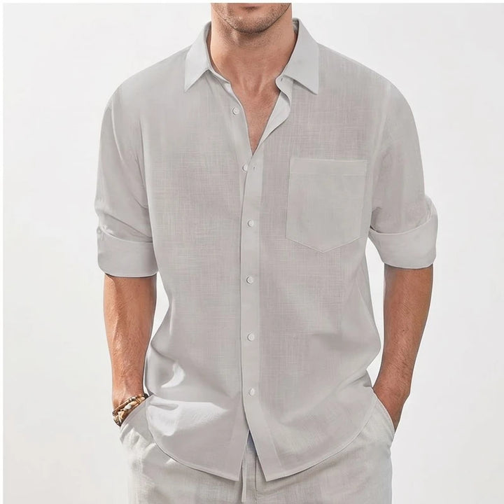Grey linen button-up shirt with pocket and rolled sleeves.