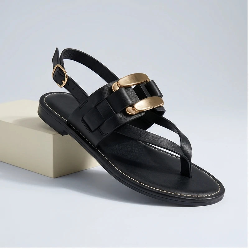Black leather t-strap sandals with gold buckle detail and slingback.