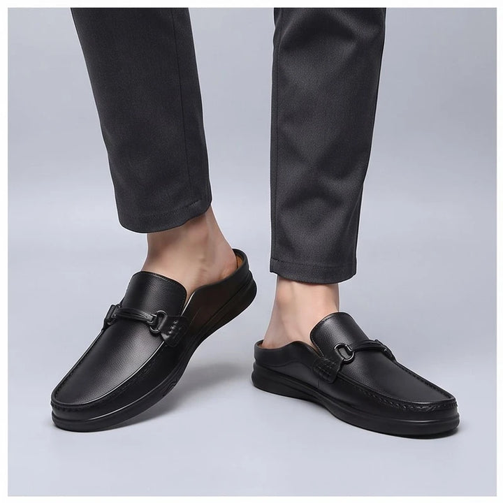 Model wearing Black leather mules in a studio