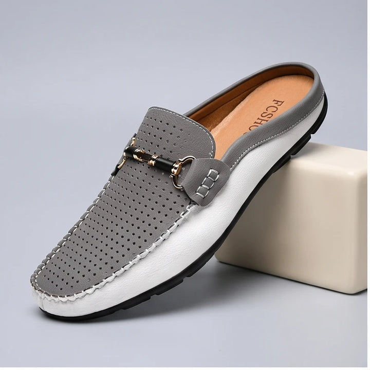 Gray leather loafers in a studio background