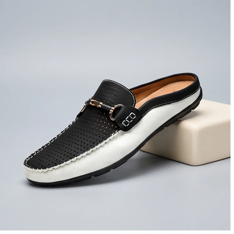 Black leather loafers in a studio background