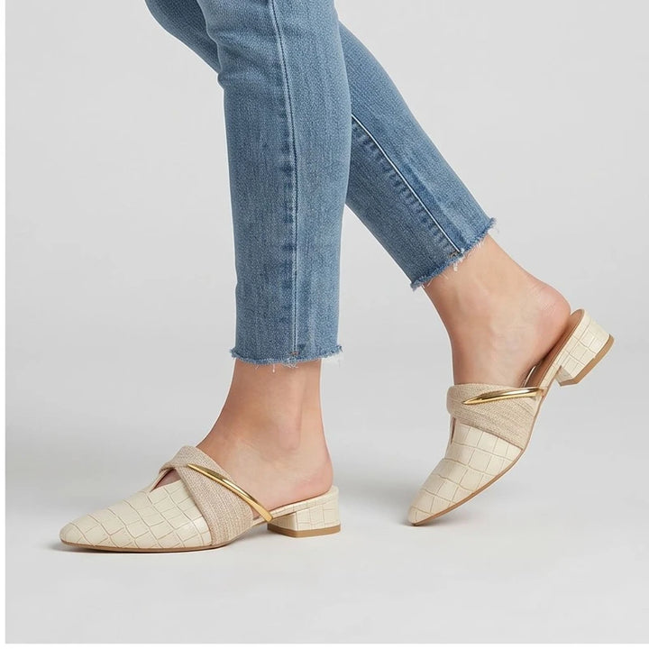 Model wearing Ivory Cream mules in a studio