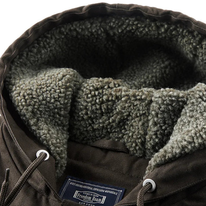 Close-up of a dark brown jacket hood with soft, textured gray sherpa lining and visible drawstrings with silver eyelets.