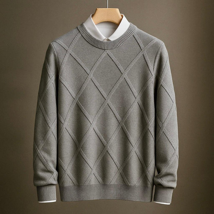 Gray patterned sweater on a hanger against a brown background