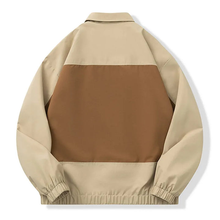 A colorblock utility jacket shown from the back, featuring a large brown rectangular panel across the center with beige sleeves, collar, and lower back panels, finished with elastic cuffs and hem.