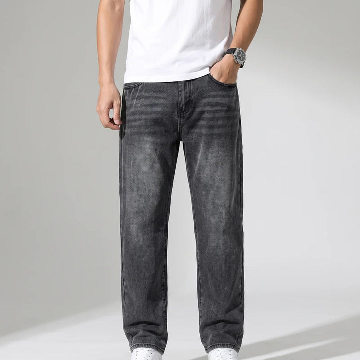 Donkergrijs jeans on an off-gray studio background