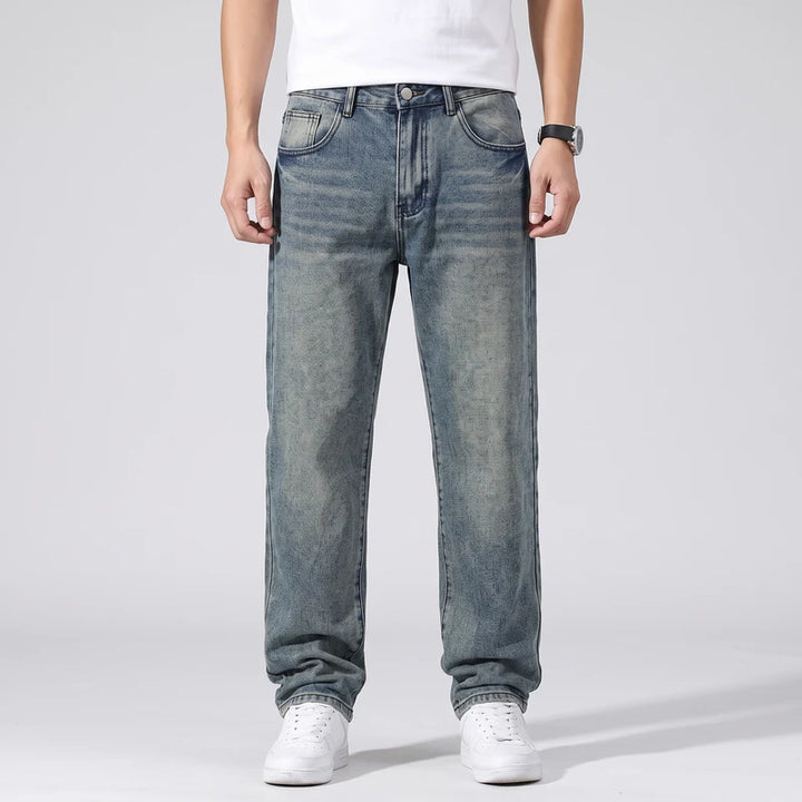 Petrol jeans on an off-gray studio background