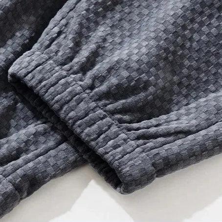 Close-up of Riden checkered corduroy pants showcasing the textured fabric and tapered fit cuffs.