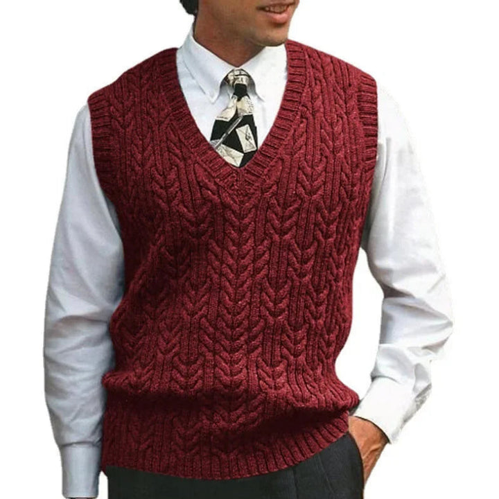 Red knitted vest worn over a white shirt with a patterned tie on a white background