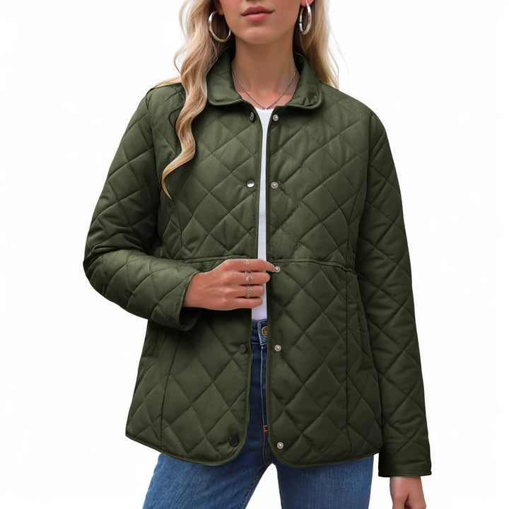 Woman wearing a dark olive green quilted jacket with a pointed collar, silver snap buttons, and a cinched waist.