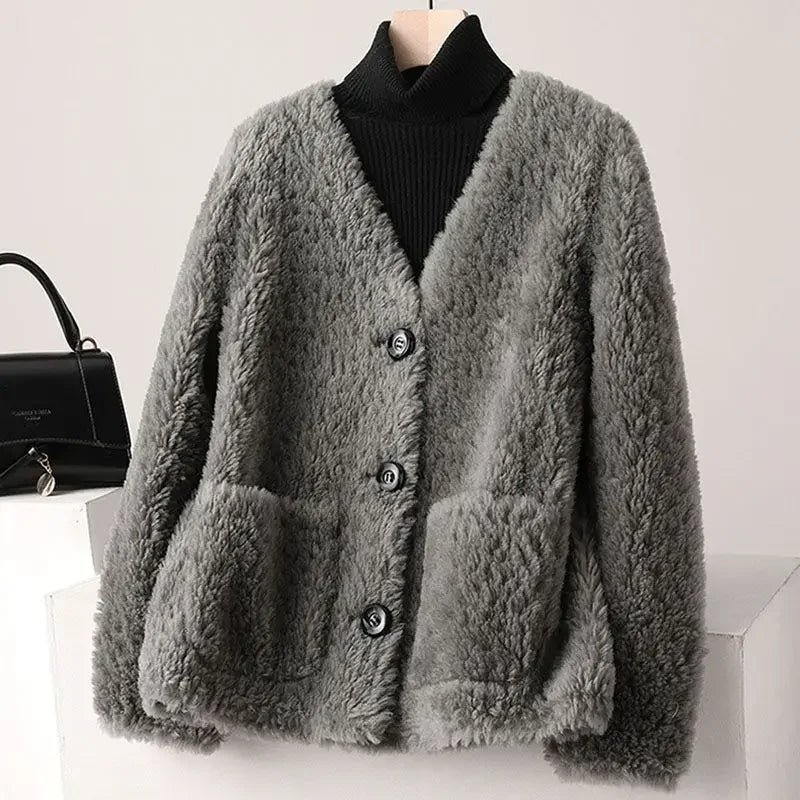 Gray fluffy cardigan on a mannequin with a black handbag in the background