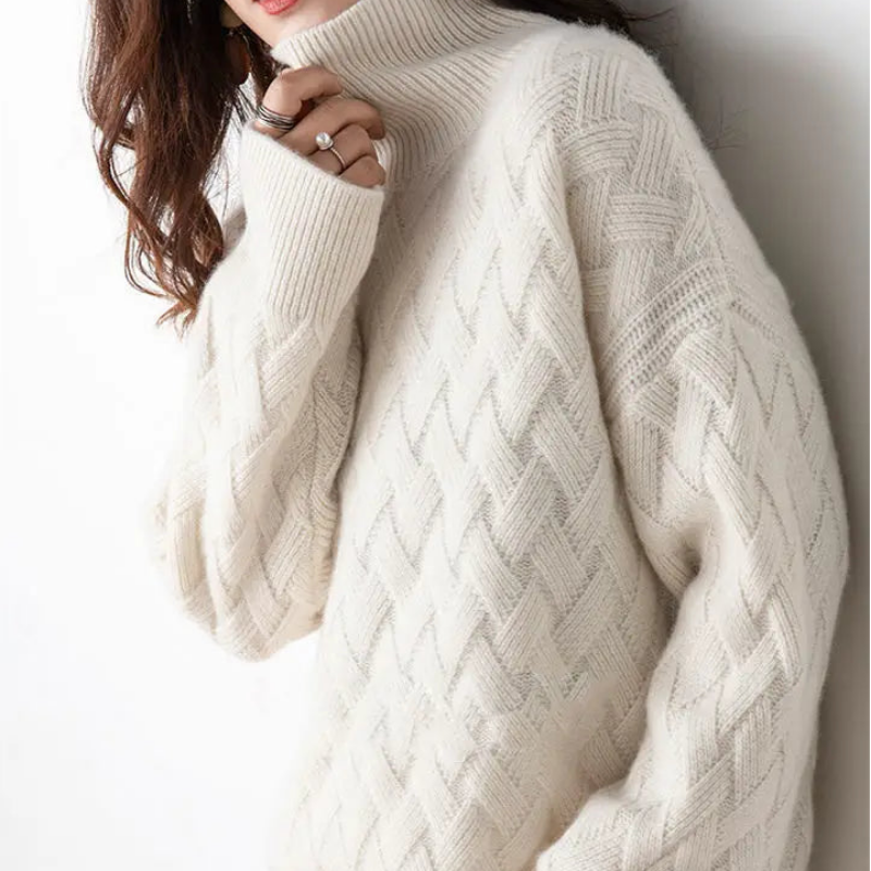 Person wearing a white cable knit sweater against a plain background