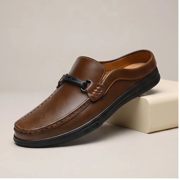 Brown leather mules in a studio background
