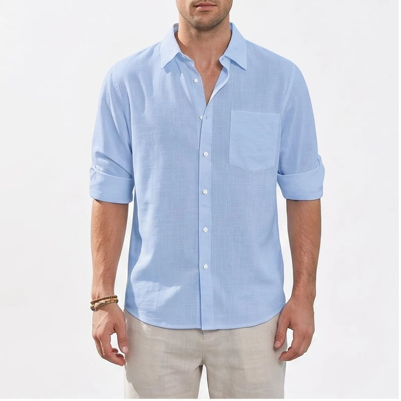 Light blue linen button-up shirt with rolled sleeves and chest pocket.