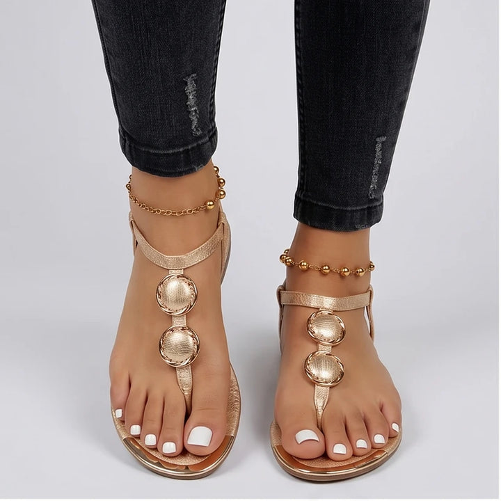 Model wearing Gold Harlow T-Strap Flat Sandals in studio