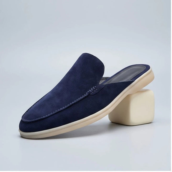 Blue suede mules in a studio background