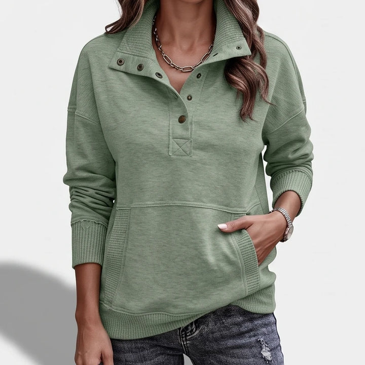 green pullover on an off-gray studio background