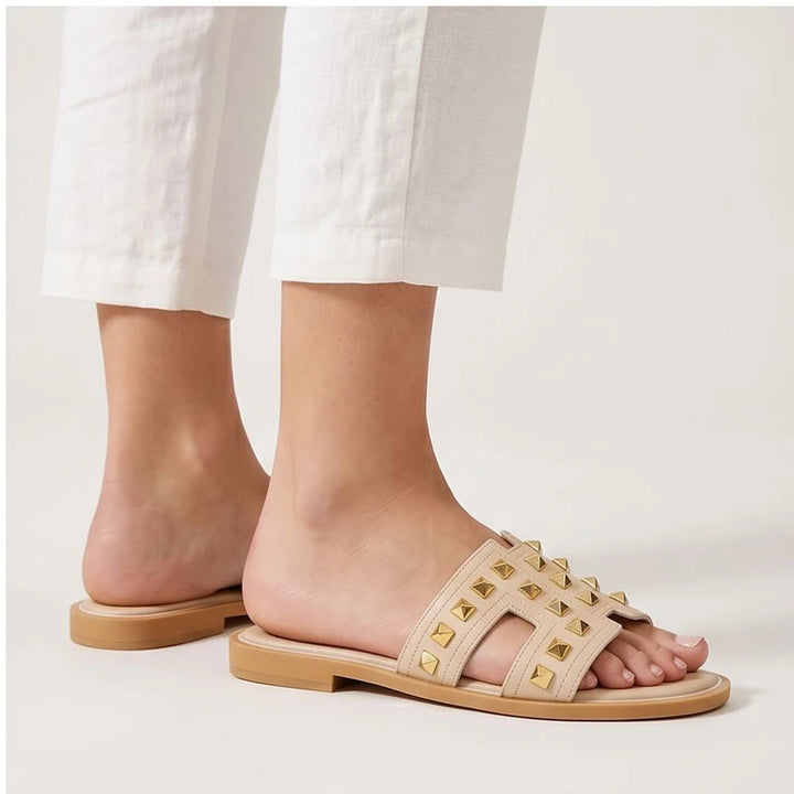 Beige leather Bellamy slides with gold studs.