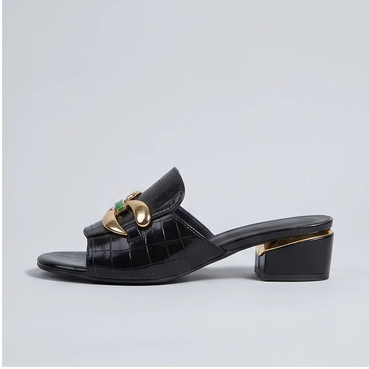 Black crocodile embossed block heel mules with gold hardware.