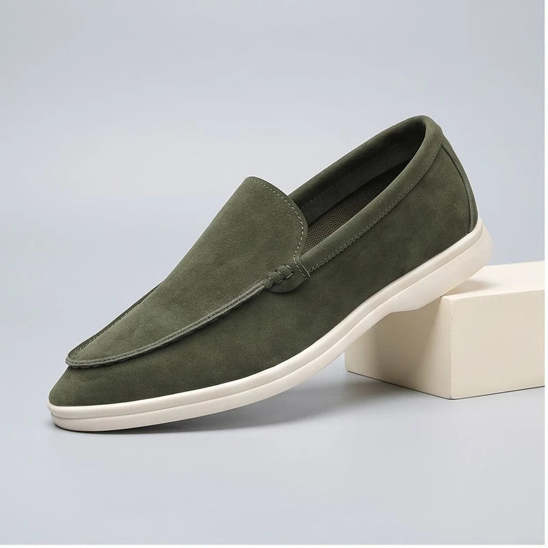 green suede loafers in a studio background