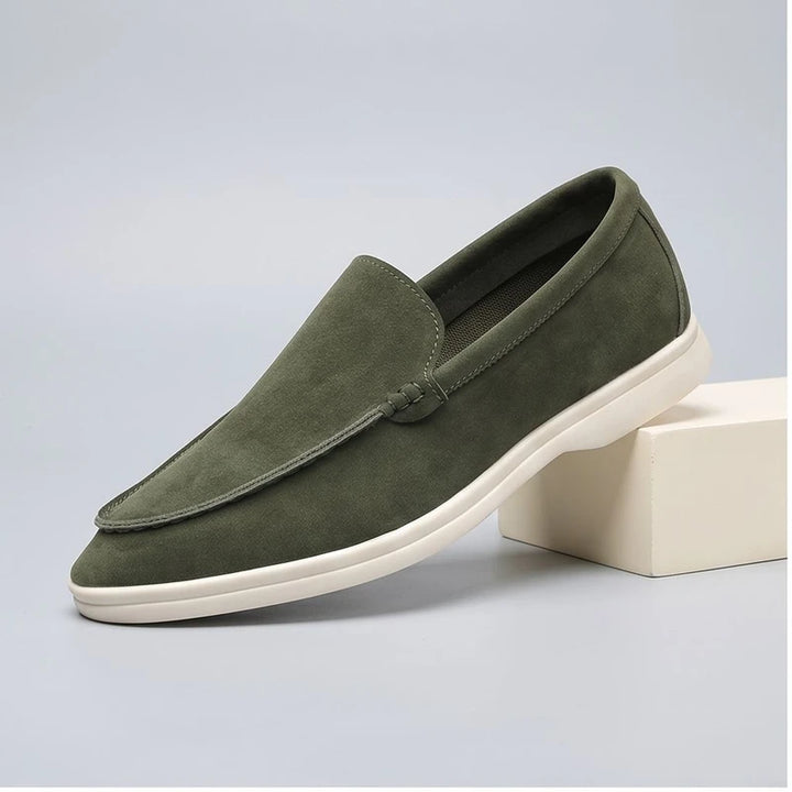 green suede loafers in a studio background