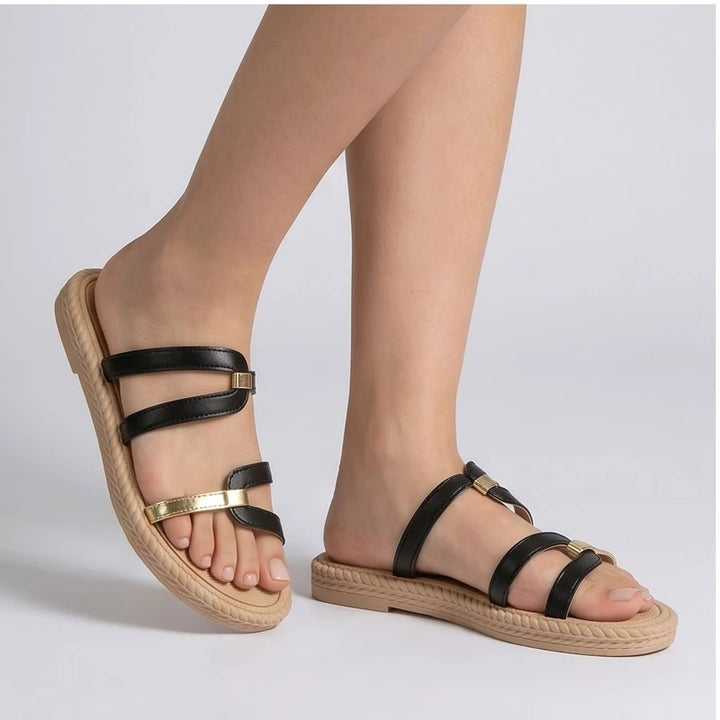 Black and gold leather slide sandals with tan soles.