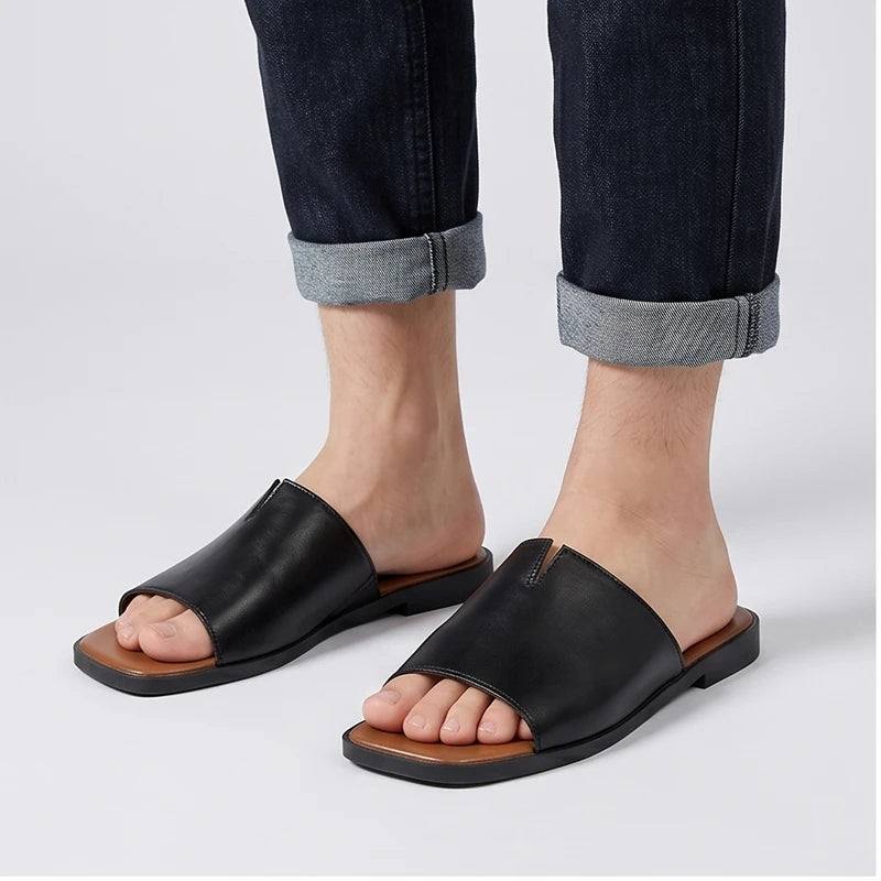 Model wearing Black Keaton Genuine Leather Slide Sandals in studio