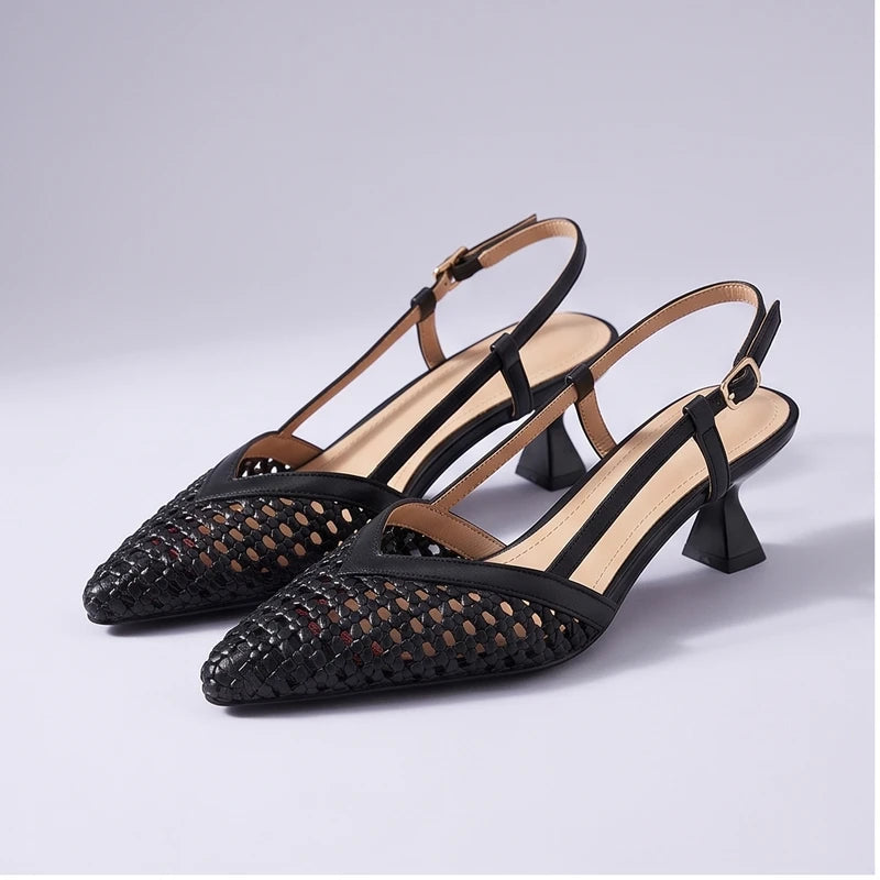 Black woven sandals in a studio background