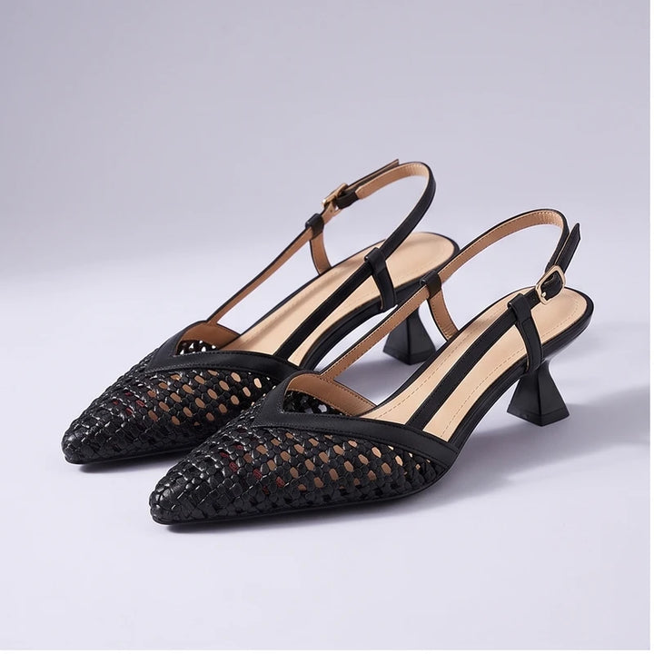 Black woven sandals in a studio background