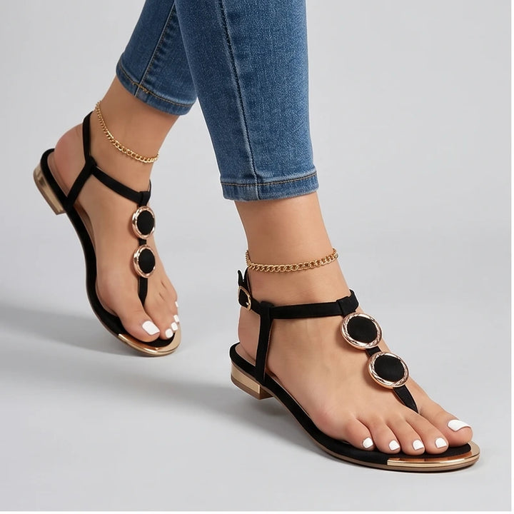Model wearing Black Harlow T-Strap Flat Sandals in studio