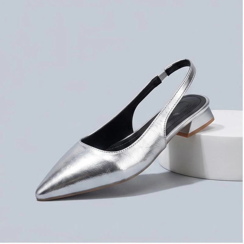 Silver leather flats in a studio background