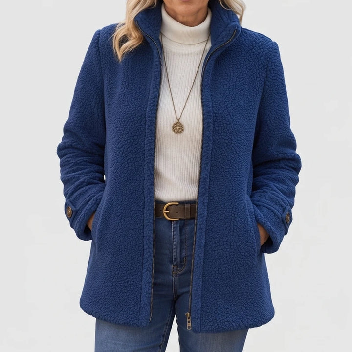 Blue fleece jacket on an off-gray studio background
