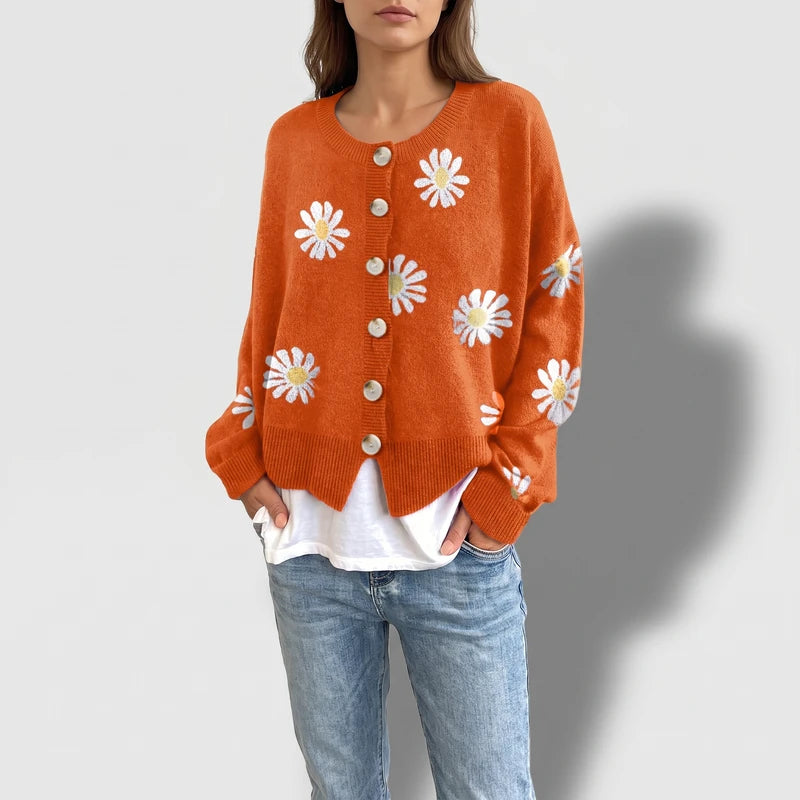 Orange knit cardigan on an off-gray studio background