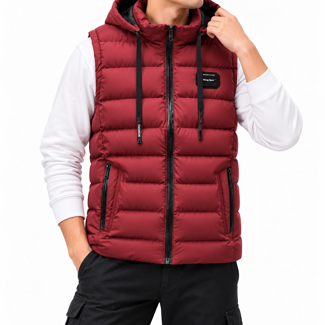 Man wearing a dark red hooded puffer vest with black zippers and drawstrings, over a white long-sleeved shirt.