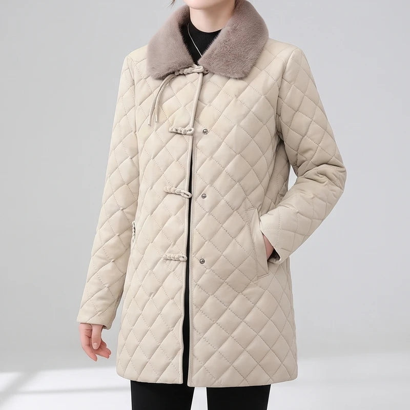 Woman wearing a beige quilted jacket with a light brown faux fur collar and traditional frog closures over metal snaps.