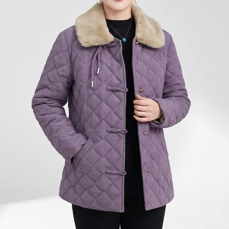 Woman wearing a quilted lavender jacket with a light brown faux fur collar and three front toggle closures.