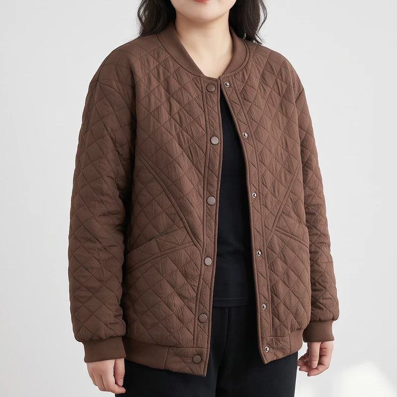 Woman wearing a brown quilted bomber jacket with a ribbed collar, cuffs, and hem, over a black shirt.