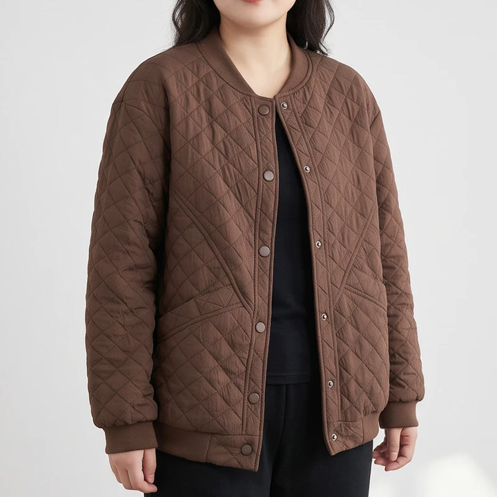 Woman wearing a brown quilted bomber jacket with a ribbed collar, cuffs, and hem, over a black shirt.