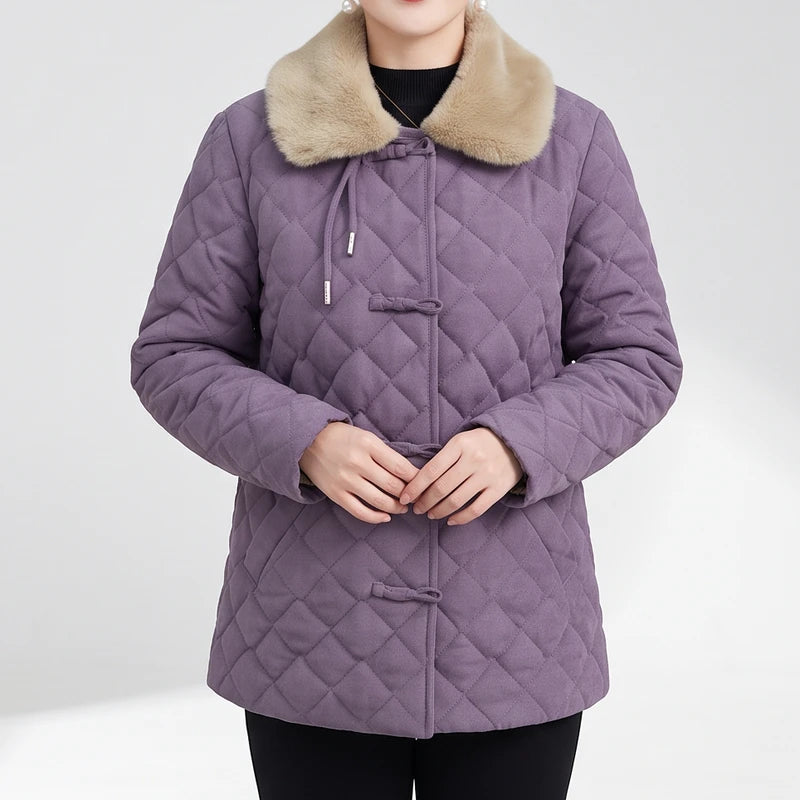 Woman wearing a purple quilted jacket with a light brown faux fur collar and traditional knot button closures.