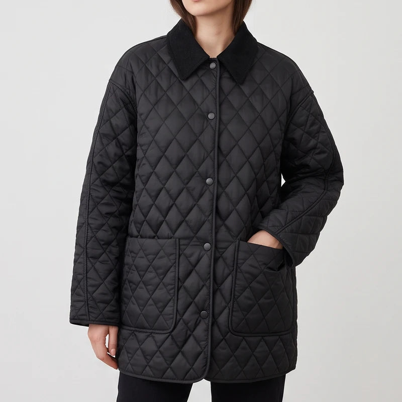Woman wearing a black diamond quilted jacket with a dark corduroy collar and large front pockets.